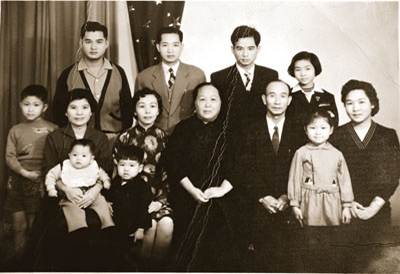 第一排中間二位長輩是林德安牧師的祖父母，左邊抱男孩的婦人是林牧師的母親和他。