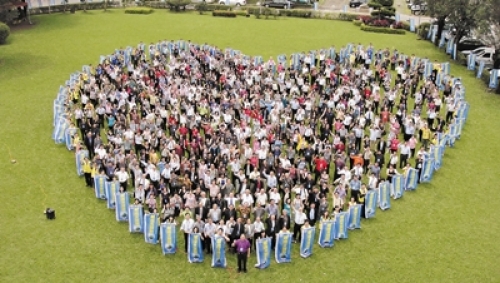 ▲與會代表廿二日在劍潭活動中心草地上合影。心型圖案表示「同心合意」。傅筱琁攝　